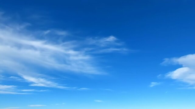Time-lapse effect of abstract, textured clouds gracefully moving across a vibrant blue sky during the day vibrant blue sky, no logos, slow motion