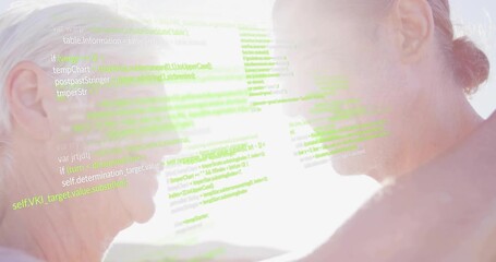senior couple embracing by sunlit shore, initiating green code overlay growing denser in technology - Powered by Adobe
