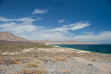 La Paz Baja California Sur Mexico, Seascape of the beach El Muerto or Ensenada de Muertos with view of the sea of ​​Cortes and mountains in the background with blue and sunny sky and clouds 