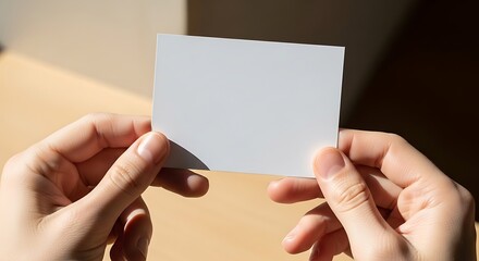 Obraz premium Hands holding blank card under natural light ready for customization