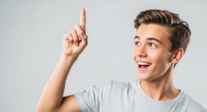 Excited Teenage Boy Pointing Upward with a Creative Idea, Isolated on White Background