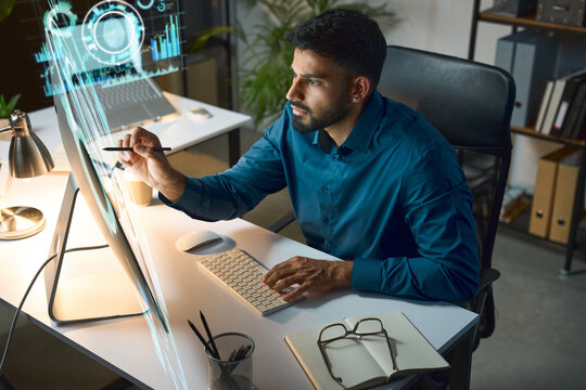 Futuristic Graphic Designer Working With Holographic Interface And AI Data Visualizations At Modern Desk