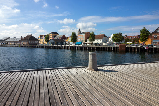 Tranquil view to the picturesque Danish coastal town Svendborg with harbour and wooden boardwalk.