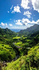 Obraz premium Panoramic view of a verdant valley, a winding river meandering through lush green hills, a blue ocean in the distance under a bright sunny sky with fluffy clouds