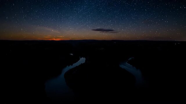 Serpentine riverbend winding through a natural landscape, transitioning from golden hour to deep night panoramic, deep night, wide shot