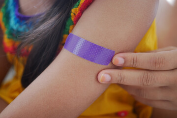 Child with colorful bandage on arm after minor injury