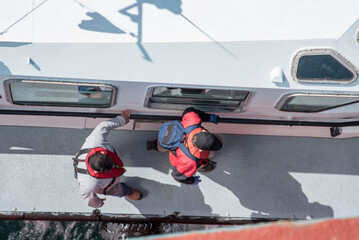 Aerial view on the pilot boat alongside the cargo ship, navigational pilot preparing to embark a...