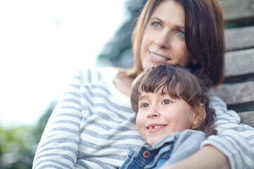 Hug, mom and child in garden on bench, motherhood and bonding together in outdoor area. Mothers Day, relax and happy family in park with seat, embrace and connection for childhood development.