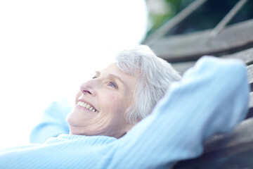 Thinking, smile and senior woman in backyard with vision, calm morning and remember memory on bench. Happy, elderly person and relax with reflection, fresh air and wellness for weekend break at house