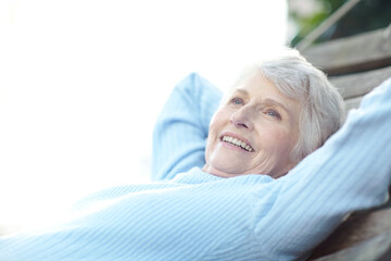 Happy, thinking and senior woman in backyard with vision, calm morning and remember memory on swing. Smile, elderly person and relax with reflection, fresh air and wellness for weekend break at house