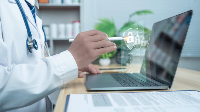 Doctor using laptop with digital security lock icons, representing patient data protection, healthcare cybersecurity, HIPAA compliance, and secure medical information system.