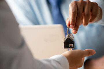 close-up handing over house keys, buying a house