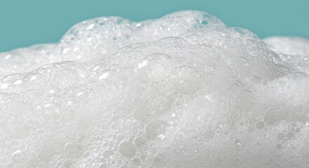 Obraz premium Captivating close-up reveals delicate white soap bubbles shimmering with light against a serene blue background, perfect for conveying purity, freshness, and clean living.