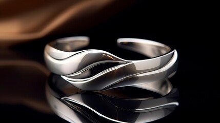 A photo of a sleek silver open cuff.