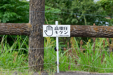 高電圧危険！獣害対策の電気柵と警告看板 (High Voltage Danger! Electric Fence for Wildlife Control)
