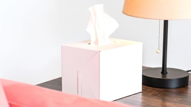 Tissue box on a bedside table with a lamp