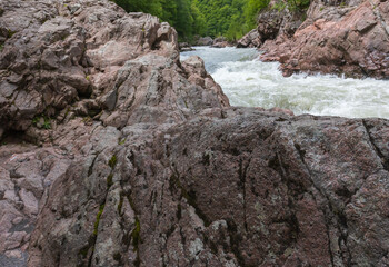 canyon of the mountain river in the summer, walking along the rocky shore
