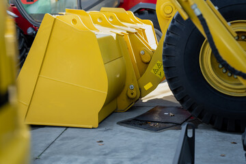 Modern construction machinery with yellow metal bucket designed for high-capacity soil movement,...