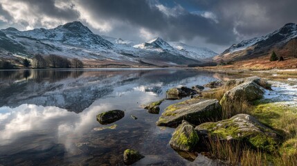Snowy mountains reflecting on calm lake