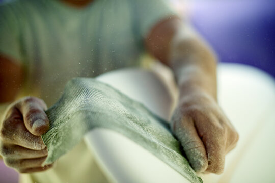 Hands, person and sanding surfboard with material to smooth surface, shaping process and repair work. Worker, dust and cloth for diy restoration, board maintenance and polish craft to prepare finish - Powered by Adobe