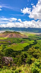 Panoramic view of a volcano over lush green valleys