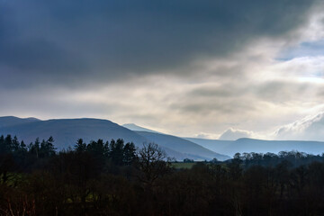 Cloudy layered landscape with mountains and trees, Brecon Beacons National Park, Wales