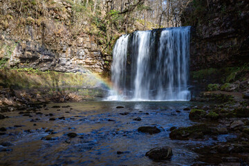 Obraz premium High waterfall with a rainbow in its mist, Sgwd Yr Eira, Brecon Beacons, Wales