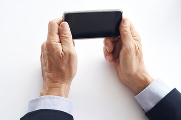 Business, hands and person in studio with phone screen for watching video, live broadcast or virtual meeting. Online, employee and man with tech, mobile app and streaming show on white background.