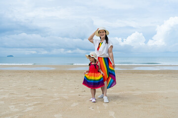 Asia and the Asian daughter are posing to take pictures of the atmosphere by the sea.