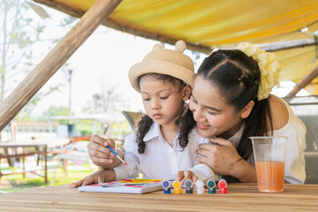 Asian mother and daughter draw people.