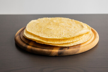 Corn Tortillas Stacked on Round Wooden Cutting Board