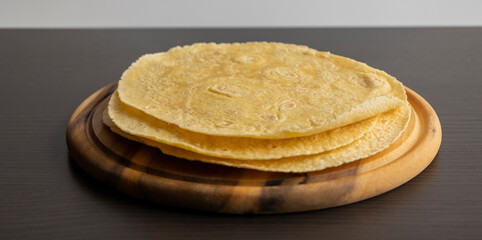 Corn Tortillas Stacked on Round Wooden Cutting Board
