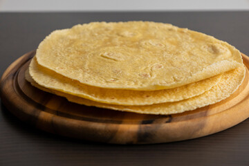 Corn Tortillas Stacked on Round Wooden Cutting Board