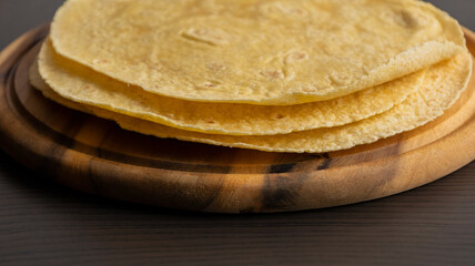 Corn Tortillas Stacked on Round Wooden Cutting Board