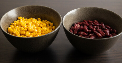 Two Dark Bowls with Drained Corn and Red Beans on Black Background