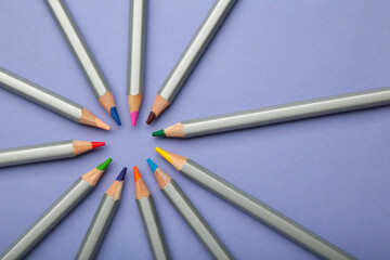 Fototapeta premium Many colorful pencils on purple background. Space for text