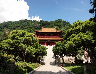 Red temple on a hillside, surrounded by trees and gardens