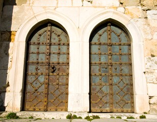 Obraz premium Two ancient arched doors in a stone wall