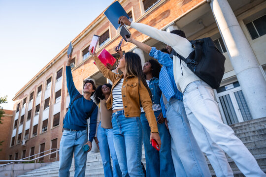 Diverse student friends celebrating success at university campus