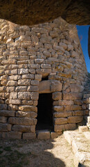Nuraghe Piscu megalithic stone tower ruins in Suelli, Sardinia, under clear blue sky