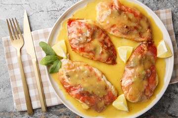 one pan chicken saltimbocca features prosciutto-draped chicken, crisp sage, and a lemony white wine sauce closeup on the plate on the table. Horizontal top view from above