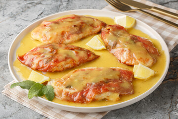 Chicken Saltimbocca is an Italian-inspired dish made with thin chicken cutlets wrapped in prosciutto and sage and lemony white wine sauce closeup on the plate on the table. Horizontal