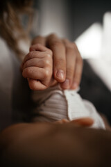 Baby touching mother's hand. Close up baby hand catch mom finger