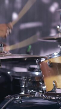 Drummer playing drum kit on stage during live music performance