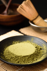 Matcha green tea powder traditional japanese healthy drink on black background