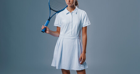 Beautiful Young Brunette Tennis Player Posing with Racquet on Gray Background