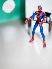 Naklejka premium Spider Man figure in his office with desktop and Computer.
