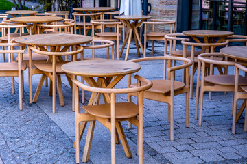 Round tables and chairs made of wood on the street.