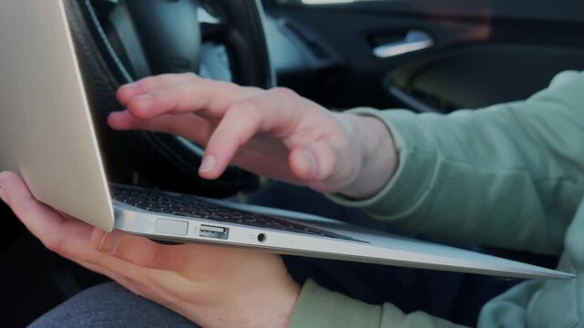 Laptop. Working on a laptop. Man in a car. Slow motion. High-quality 4K video.