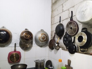 A collection of traditional cooking ware and gongs displayed on a wall, commonly used in cultural music and heritage performances. Perfect for tradition, culture, and ethnic themes.